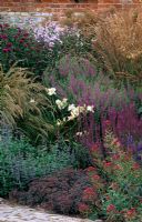 Summer border with Calamagrostis 'Karl Foerster', Stipa calamagrostis, Sedum 'Sunset Cloud', Hemerocallis 'Gentle Shepherd' and Lythrum virgatum