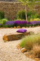 Gravel garden with rock seat, purple cushion and Salvia 'Wesuwe' 