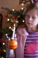 A Christingle from the children's Christmas service. Candles, oranges and sweets -Dolly mixtures with a red ribbon