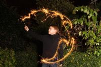 Boy playing with sparklers in the dark