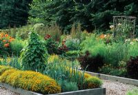 Potager vegetable garden with integrated annuals and vegetables. Runner beans on teepee obelisk plant support. Raised beds with wooden edges - Bainbridge Island, Oyster Point, Seattle, USA