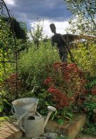 Border of Sedum and sculpture, Bucket and watering can - Suffolk
