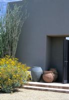 Contemporary desert garden with house wall, steps, front door, drought tolerant planting and empty urns pots as a focal point - The Stiteler Garden, Phoenix, USA