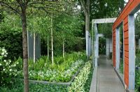 Malus 'Evereste' and water feature in contemporary garden with long concrete path - 'A tribute to Linnaeus' garden,  Chelsea 2007