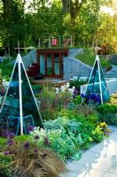 Glass prism obelisks in borders of Carex buchananii ,Red Rooster,, Iris 'Kent Pride', Iris 'Dusky Challenger', Lavandula stoechas 'Dark Form' - 'The Marshall's Sustainability Garden', Chelsea 2007