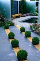 Buxus balls in slate and timber paving leading to sqaure pond - 'Then and Now' garden, Hampton Court 2007