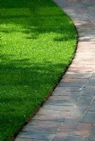 Curved Brick path with neatly edged lawn  in May