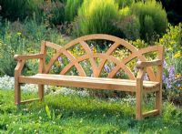 Teak bench infront of flowerbed in garden