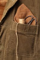 Corduroy jacket with a spotted handkerchief, roll of natural jute garden twine and scissors in top pocket