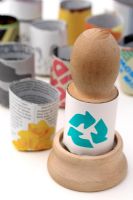 Wooden paper potter with recycling symbol on paper pot and biodegradable recycled newspaper pots in background