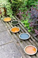 Coloured pot holders used as decoration or bird bath