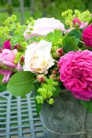 Achemilla mollis, Rosa 'Madame Isaac Periere' and mixed Rosa in an old metal bucket 
