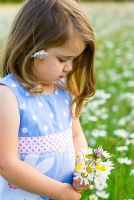 Little girl holding a posy of daisies and clover