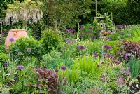 View of entrance garden at Merriments, East Sussex with Tradescantia, Allium, Geranium, Clematis and Wisteria