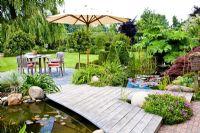 Sitting area with umbrella beside pond