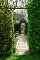 View through hawthorn hedge entrance down path of vegetable garden at Little Becketts, Essex