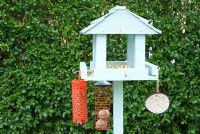 Bird table with bird seed, apples and suspended feeders