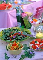 Plates of party food - Peppers, salads cheese and Borage flowers and foliage for decoration 