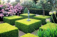 Formal garden with clipped Buxus and small figurative statue