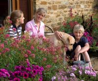 Family relaxing in the garden with their pet dog