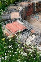 Steel cages filled with recycled building materials to create a curved seat
