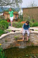 Childrens' garden with boy playing with water