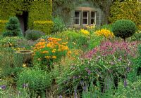 Flower garden including Veronica longifolia, Tradescantia, Geraniums, Alstroemeria aurea 'Dover orange' and box topiary - Herterton House, nr Cambo, Morpeth, Northumberland