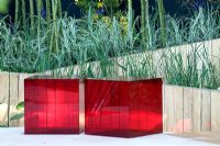 Two red perspex blocks as seats against a curved oak wall. Garden - The Lloyd's TSB Garden Travellers Retreat, RHS Chlesea Flower Show 2008. Design - Trevor Tooth, Sponsor - Lloyds TSB
