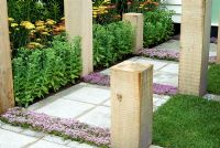 Path with Thymus planted in paving, edged with oak posts, Sedum and Achillea - Hampton Court Flower Show 2007
