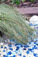Blue pebbles under ornamental grass