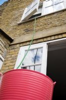Siphoning grey water, used bath water, from the bathroom to use to water the garden