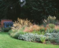 View from the main lawn to small greenhouse with Stipa gigantea, Stachys and Pampas grass - Greystone Cottage, Oxfordshire