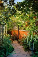 Roof garden with path and low terracotta coloured wall, metal gate and containers with Phormium and Acanthus mollis - Vancouver, Canada