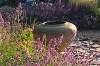 Gravel garden with Nepeta 'Walkers Low', slate and large empty urn