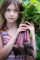 Girl holding a bunch of beetroot