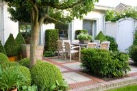 Dining area on terrace with topiary and trees