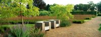 Seating area in the Drifts of Grasses Garden planted with Molinia caerulea subsp. Caerulea within the walled Garden at Scampton designed by Piet Oudolf