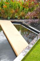Garden pond with wooden pathway across 