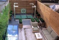 Contemporary rooftop garden with decking, seating, lighting and Buxus spheres in containers - Wilton Place, London