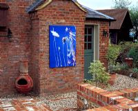 Outdoor canvas photograph hanging on a brick wall in a courtyard