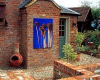 Outdoor canvas photograph hanging on a brick wall in a courtyard