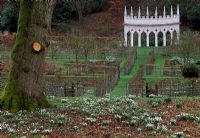 The Exedra, beyond geometrical vegetable gardens and snowdrops, at Painswick Rococo Garden, Painswick, Gloucestershire