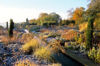 A water rill with frost on perennials and ornamental grasses at Broughton Grange, Oxfordshire
