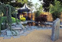 Japanese style garden showing pool edged with slate and pagoda summerhouse in the background at the Hampton Court Flower Show
