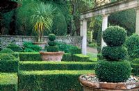 Beside the Casita is a formal garden of box hedges framing pots from a villa near Siena - Iford Manor, Bradford-on-Avon, Wiltshire