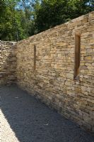 Contemporary dry stone walls in walled courtyard for car parking