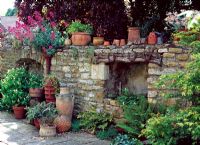 Old stone wall with horseshoes and terracotta pots on top