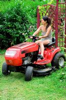 Woman on ride on lawn mower