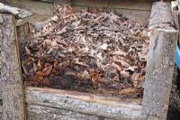 Removing front boards from compost bin prior to removing contents