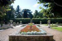Raised bed with Pelargoniums and stone urns in the Italian Garden at Arley Arboretum, Worcestershire, by kind permission of the Trustees of the R D Turner Charitable Trust